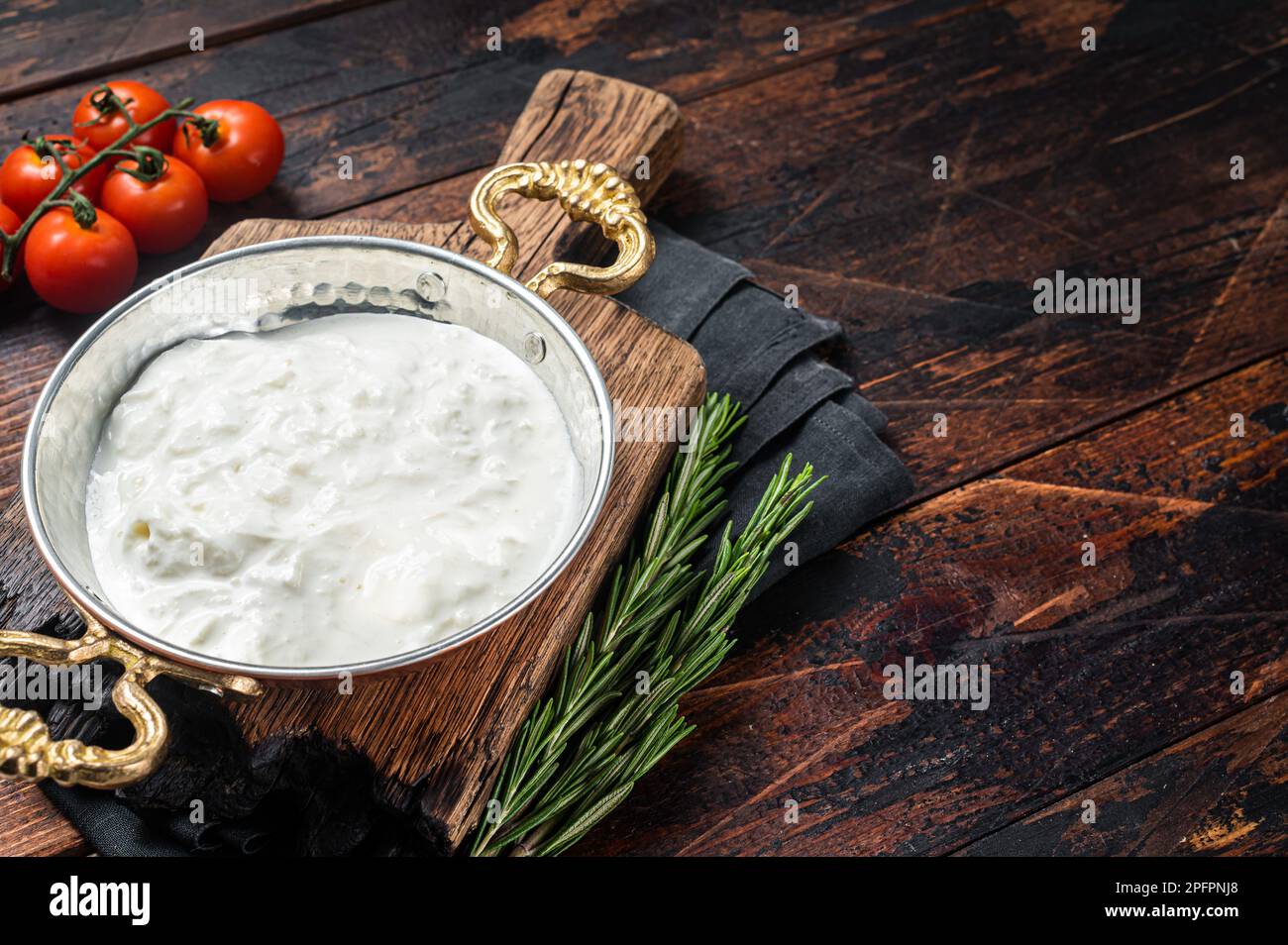 Straciatella fresh italian creamy cheese. Wooden background. Top view. Copy space. Stock Photo