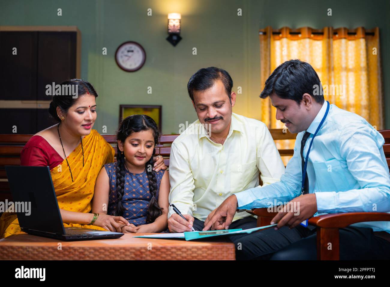 Bank officer taking sign from couple for insurance documents at home - concept of future investment, financial and agreement. Stock Photo