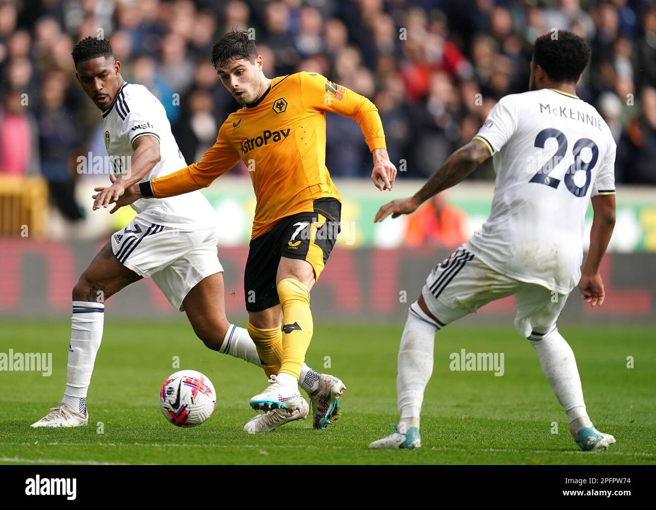 Wolverhampton Wanderers' Pedro Neto (centre) battles for the ball with Leeds United's Junior Firpo (left) and Weston McKennie during the Premier League match at Molineux Stadium, Wolverhampton. Picture date: Saturday March 18, 2023. Stock Photo