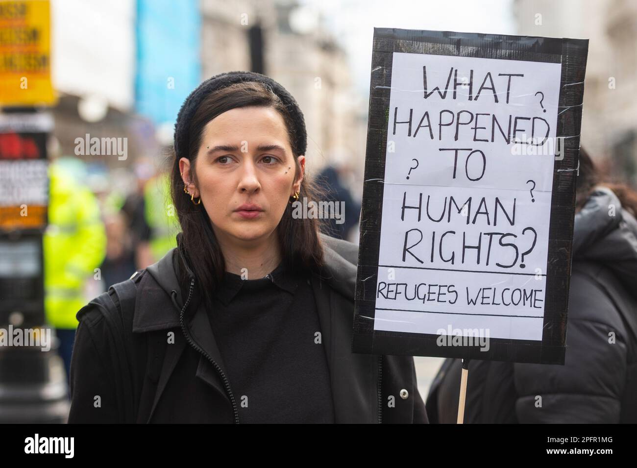 London, UK. 18 March 2023. A woman with a sign takes part in a 'Resist ...