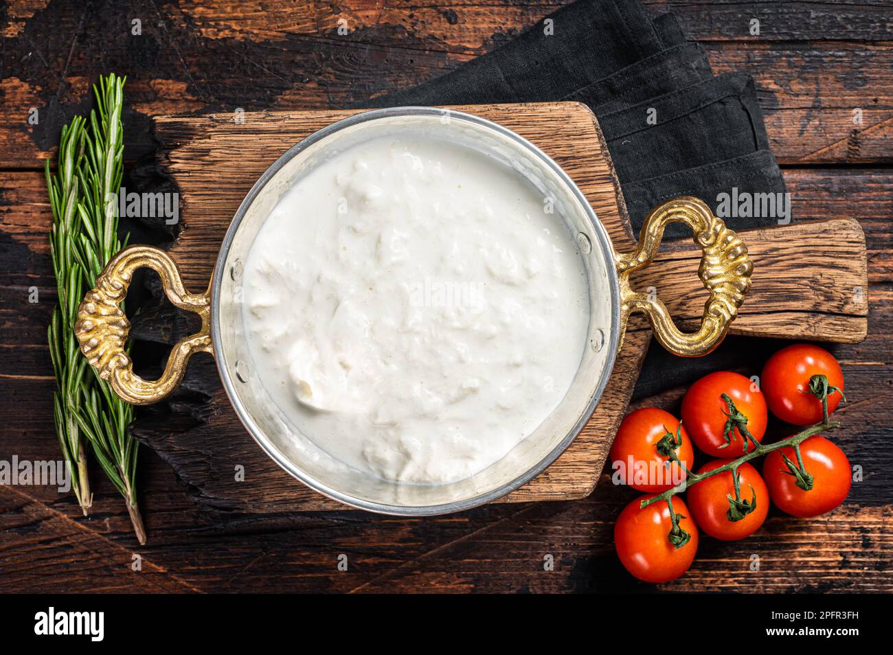 Straciatella fresh italian creamy cheese. Wooden background. Top view. Stock Photo