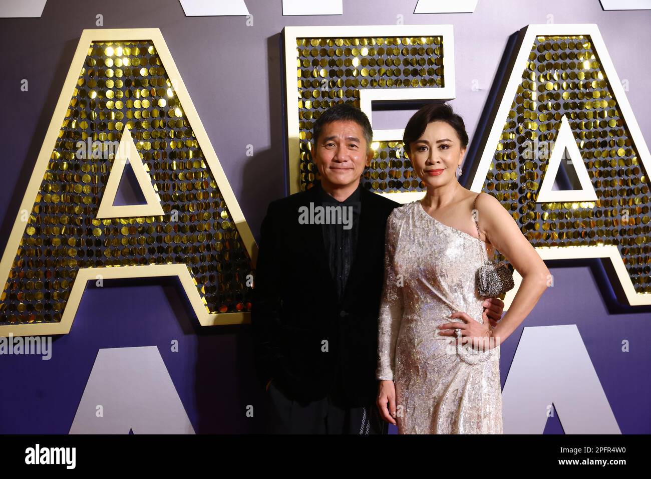 Actor Tony Leung Chin-wai (left) and his wife Carina Lau Ka-ling (right) pose at the red carpet at the 16th Asian Film Awards at Hong Kong Palace Museum, in Hong Kong.   12MAR23.   SCMP / Dickson Lee Stock Photo