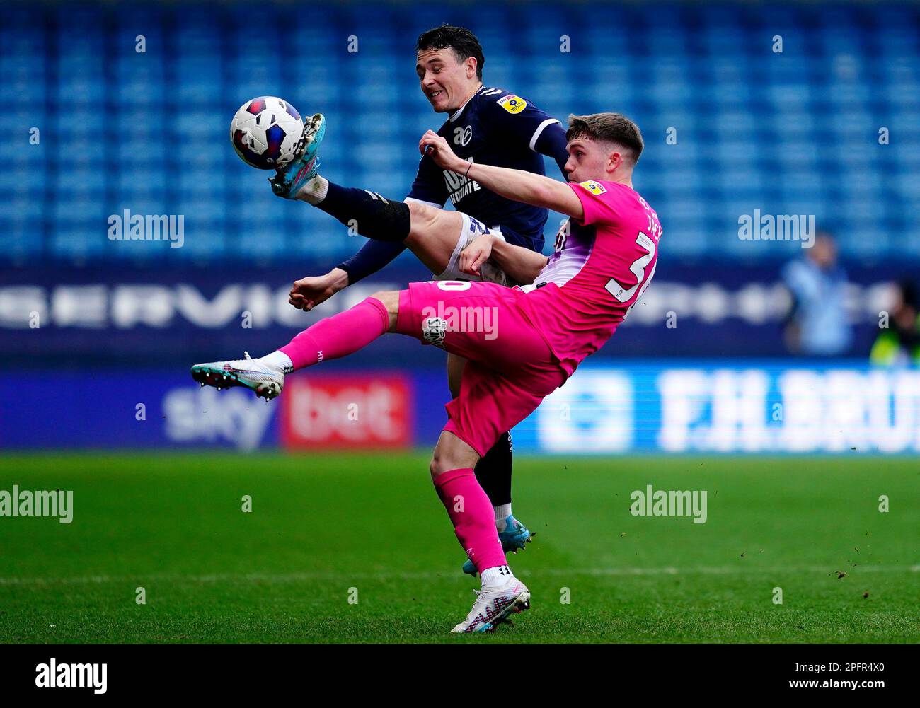 Millwall's Danny McNamara (left) and Huddersfield Town's Ben Jackson battle for the ball during the Sky Bet Championship match at The Den, London. Picture date: Saturday March 18, 2023. Stock Photo
