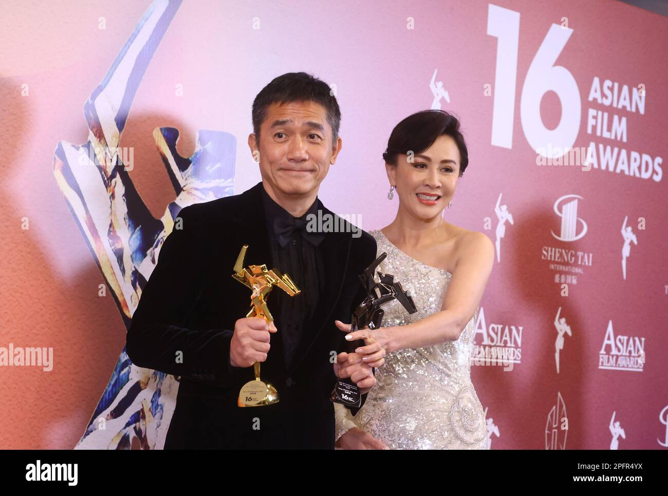 Tony Leung Chiu-wai, winning the Asian Film Contribution Award and Best Actor on HHhere The Wind BlowsHHin the 16th Asian Film Awardsposes for the media with his wife Carina Lau Ka-ling at Hong Kong Palace Museum, in Hong Kong.   12MAR23.   SCMP / Dickson Lee Stock Photo