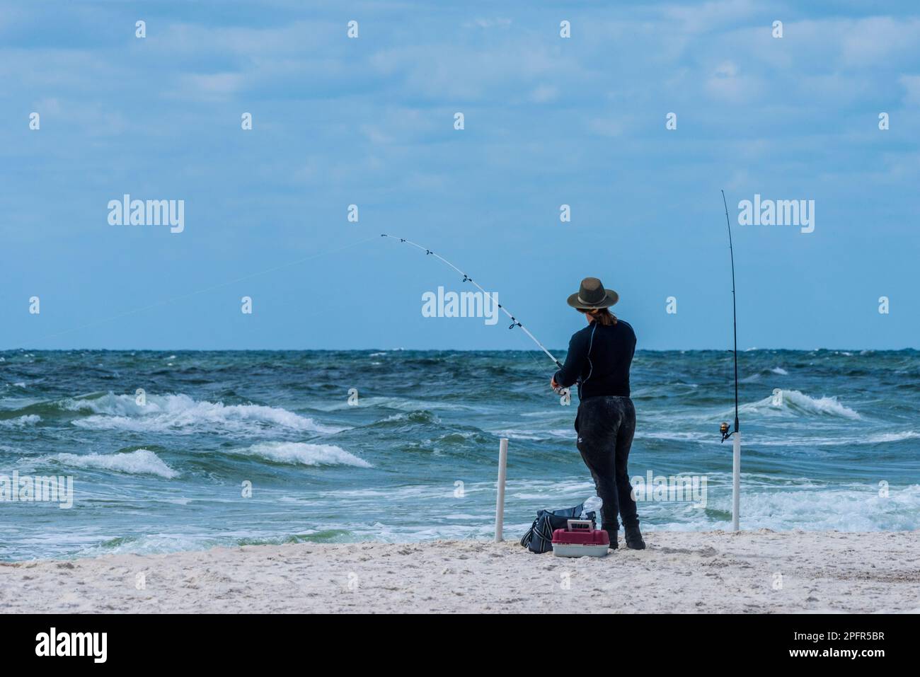 A fisherman minds his lines on Perdido Key Beach in Florida on March 16