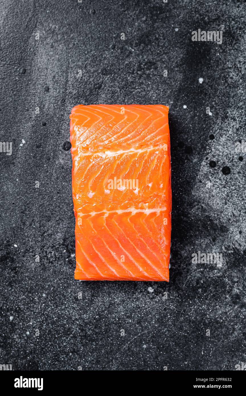 Raw salmon fillet steaks on kitchen table. Black background. Top view ...