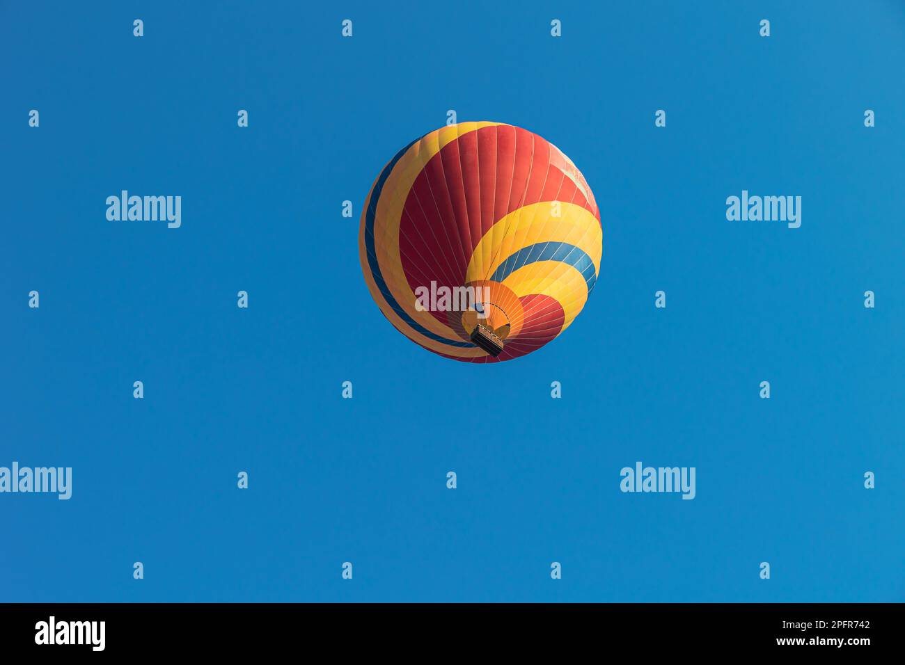 A beautiful hot air balloon soaring through a clear blue sky Stock ...