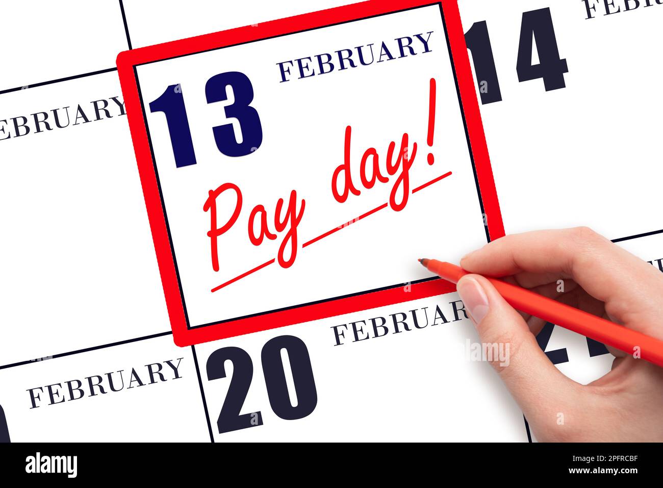 13th day of February. Hand writing text PAY DATE on calendar date February 13 and underline it. Payment due date.  Reminder concept of payment. Winter Stock Photo