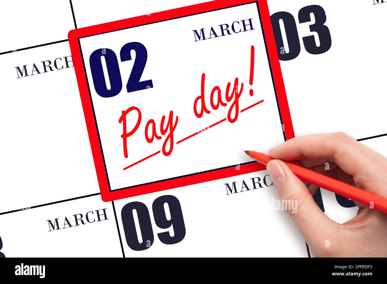 2nd day of March. Hand writing text PAY DATE on calendar date March 2 and underline it. Payment due date.  Reminder concept of payment. Spring month, Stock Photo