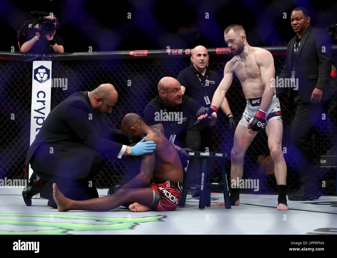 Canada's Malcolm Gordon (second left) is seen to by officials after the referee ended his Men's Flyweight bout against United Kingdom's Jake Hadley (second right) during UFC 286 at 02 Arena, London Picture date: Saturday March 18, 2023. Stock Photo