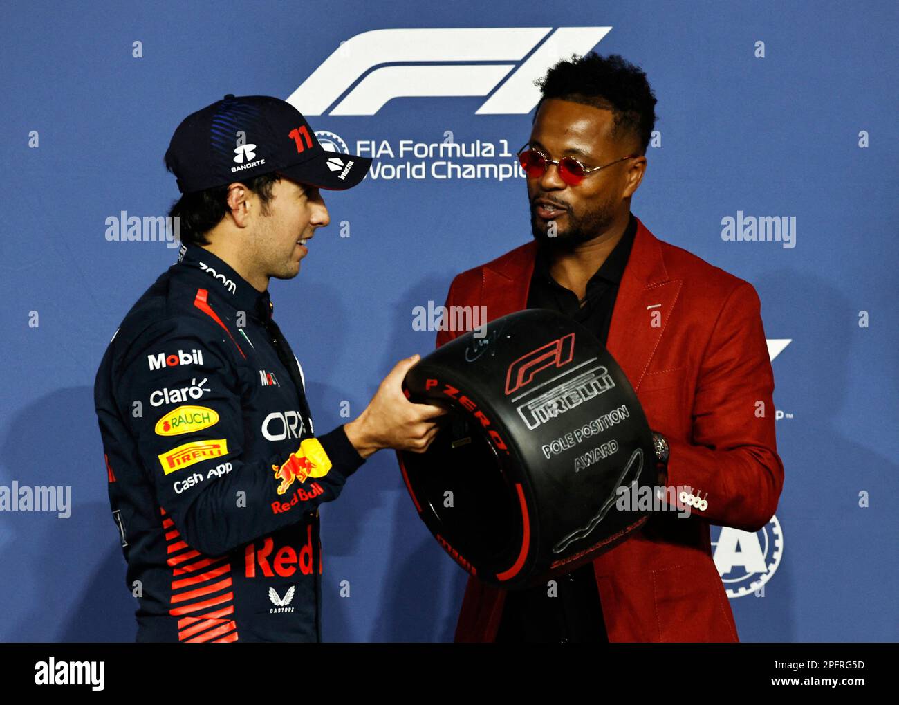 Formula One F1 - Saudi Arabian Grand Prix - Jeddah Corniche Circuit, Jeddah, Saudi Arabia - March 18, 2023 Red Bull's Sergio Perez is presented with the pole position trophy by former footballer Patrice Evra REUTERS/Hamad I Mohammed Stock Photo