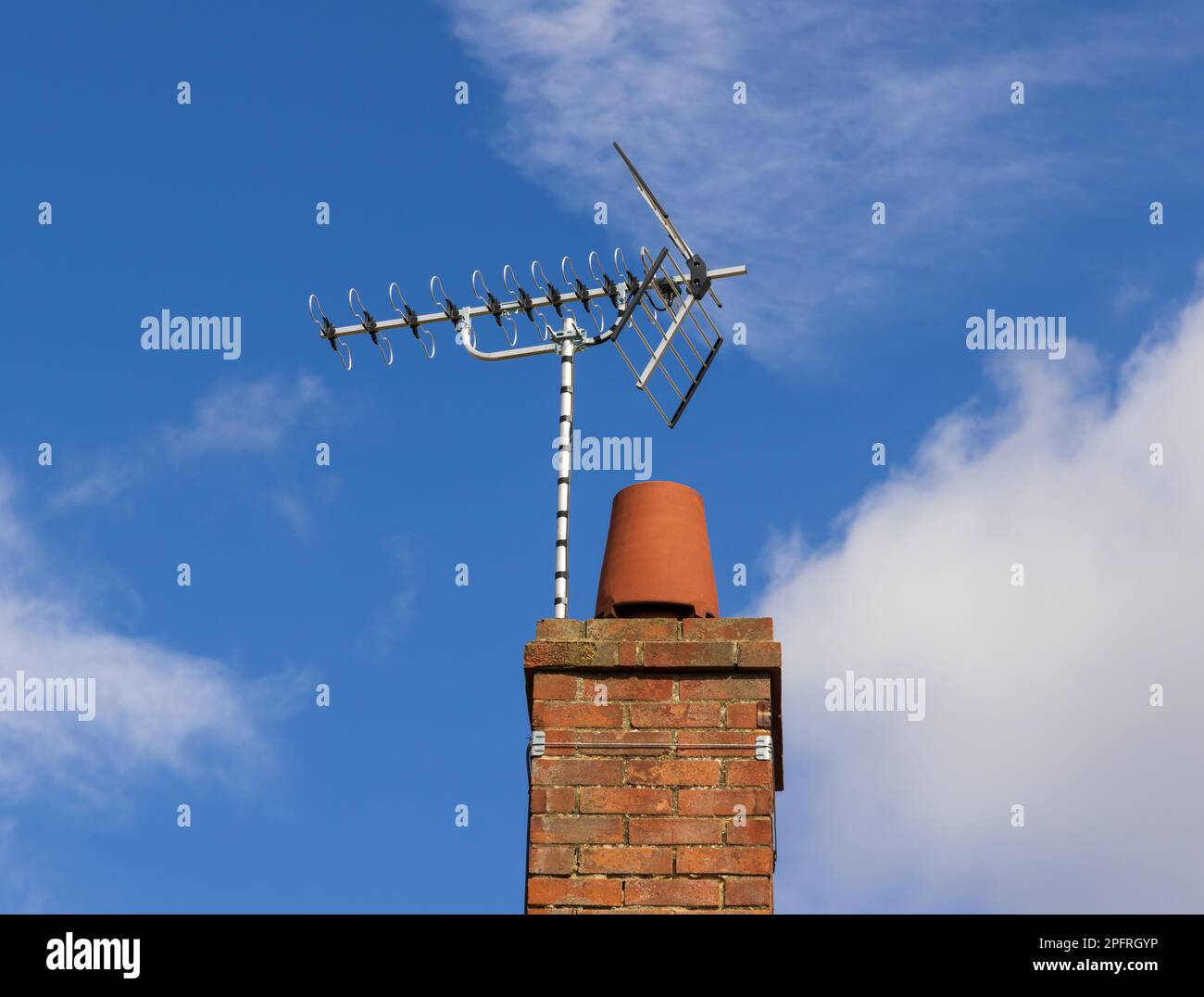 A newly installed wide band television aerial on a chimney against a blue sky.   UK Stock Photo