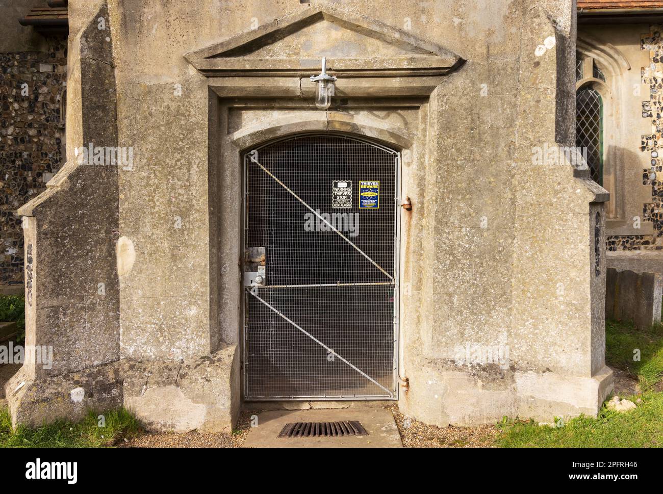 Entrance to a church protected with a security door to protect the building from theft.  Holy Trinity Church, Middleton, Suffolk. UK Stock Photo