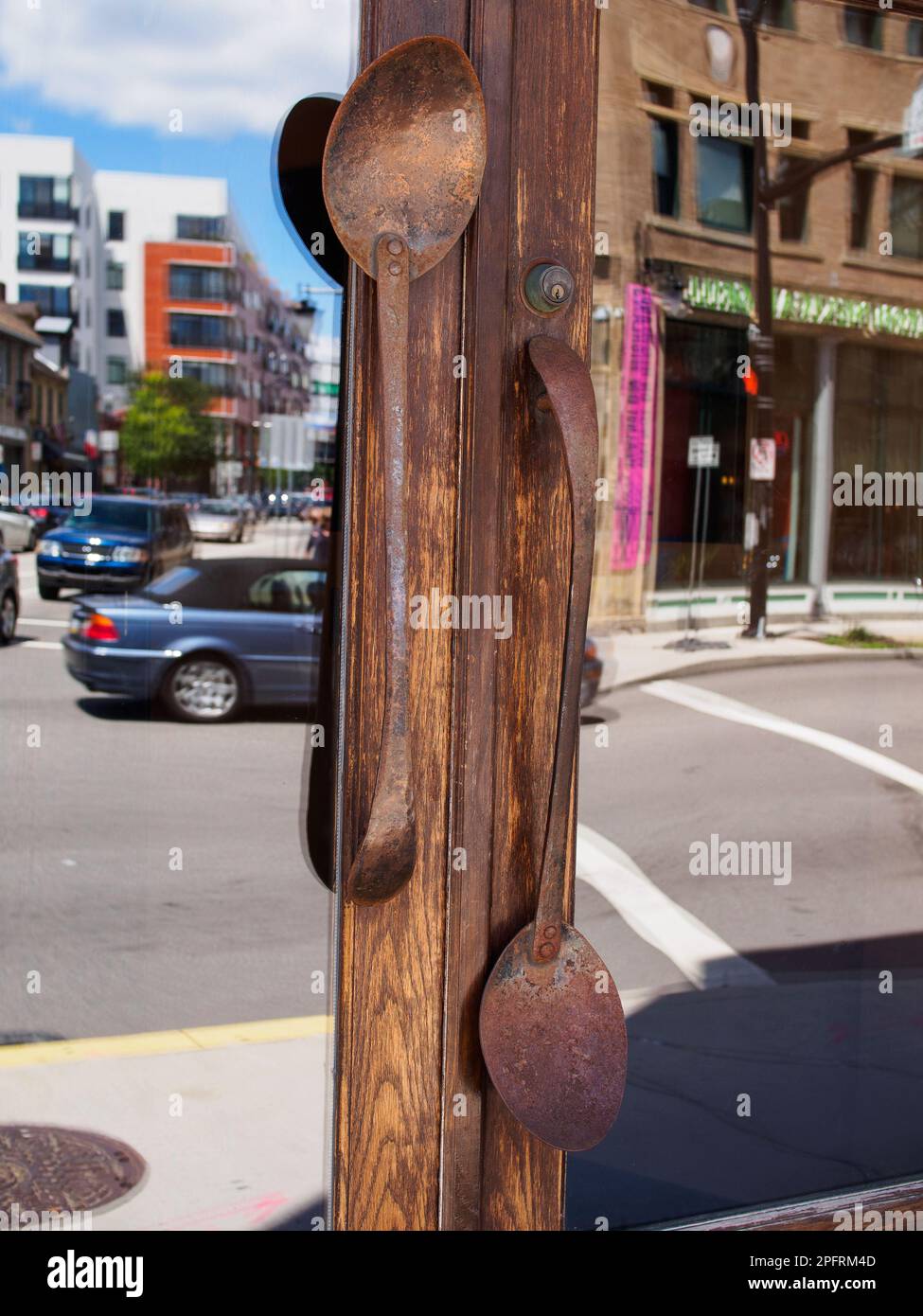 This photograph captures a truly unique and eclectic design feature: door handles made of old, large spoons. These handles add a touch of whimsy and c Stock Photo