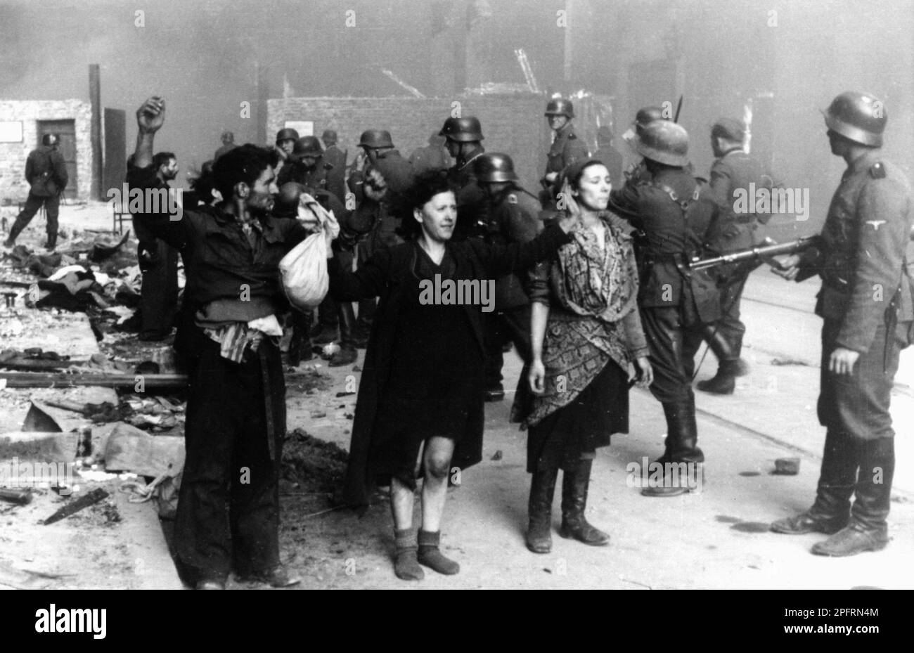 In January 1943 the nazis arrived to round up the Jews of the Warsaw Ghetto  The Jews, resolved to fight it out, took on the SS with homemade and primitive weapons. The defenders were executed or deported and the Ghetto area was systematically demolished. This event is known as The Ghetto Uprising. This image shows a group of jewish women surrendering, hands up, to German soldiers. Woman on the right has been named as Hasia Szylgold-Szpiro. This image is from the German photographic record of the event, known as the Stroop report. Stock Photo