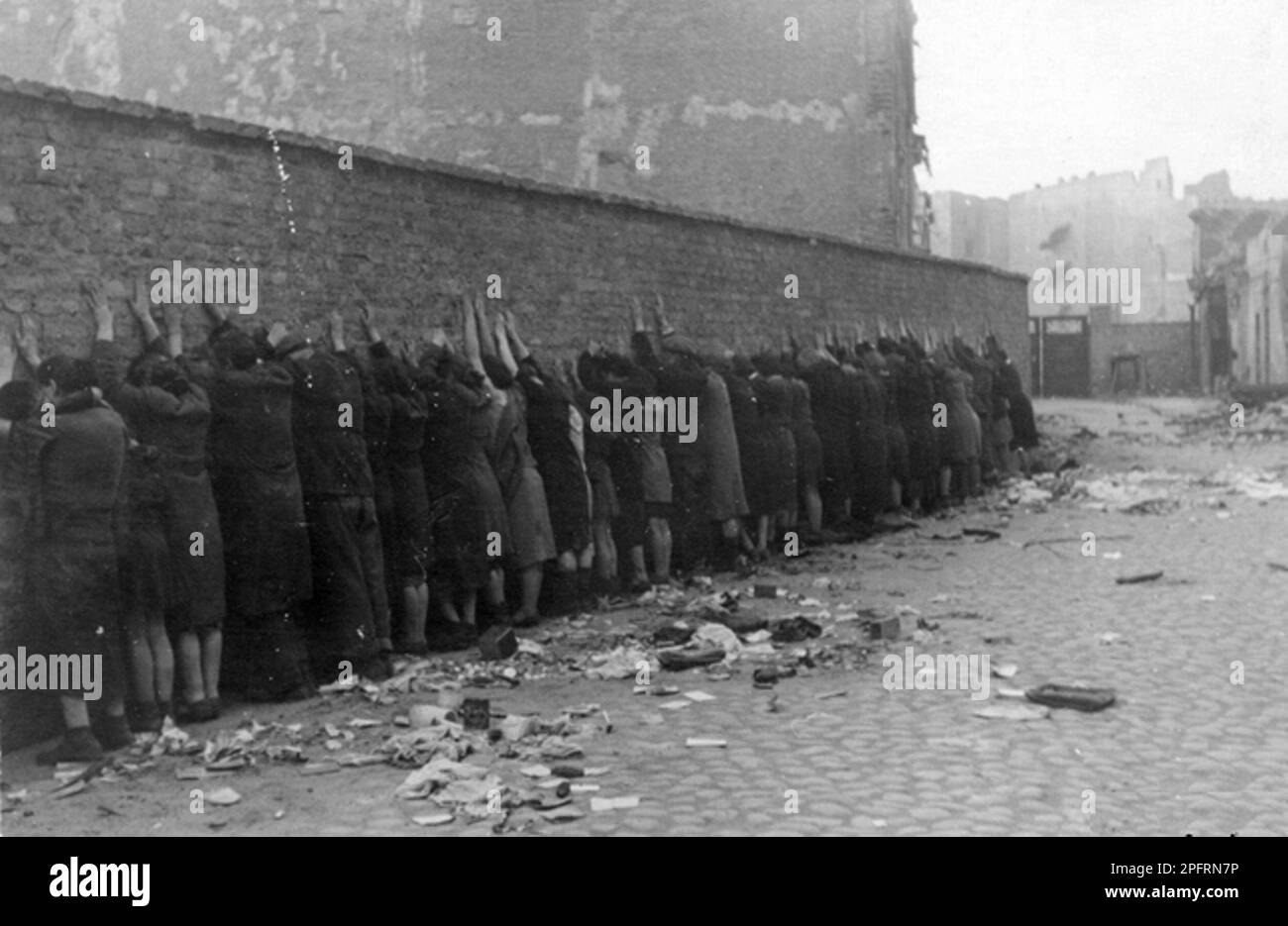 In January 1943 the nazis arrived to round up the Jews of the Warsaw Ghetto  The Jews, resolved to fight it out, took on the SS with homemade and primitive weapons. The defenders were executed or deported and the Ghetto area was systematically demolished. This event is known as The Ghetto Uprising. This image shows Jews captured by the SS during the suppression of the Warsaw Ghetto Uprising are lined up against a wall prior to being searched for weapons. This image is from the German photographic record of the event, known as the Stroop report. Stock Photo