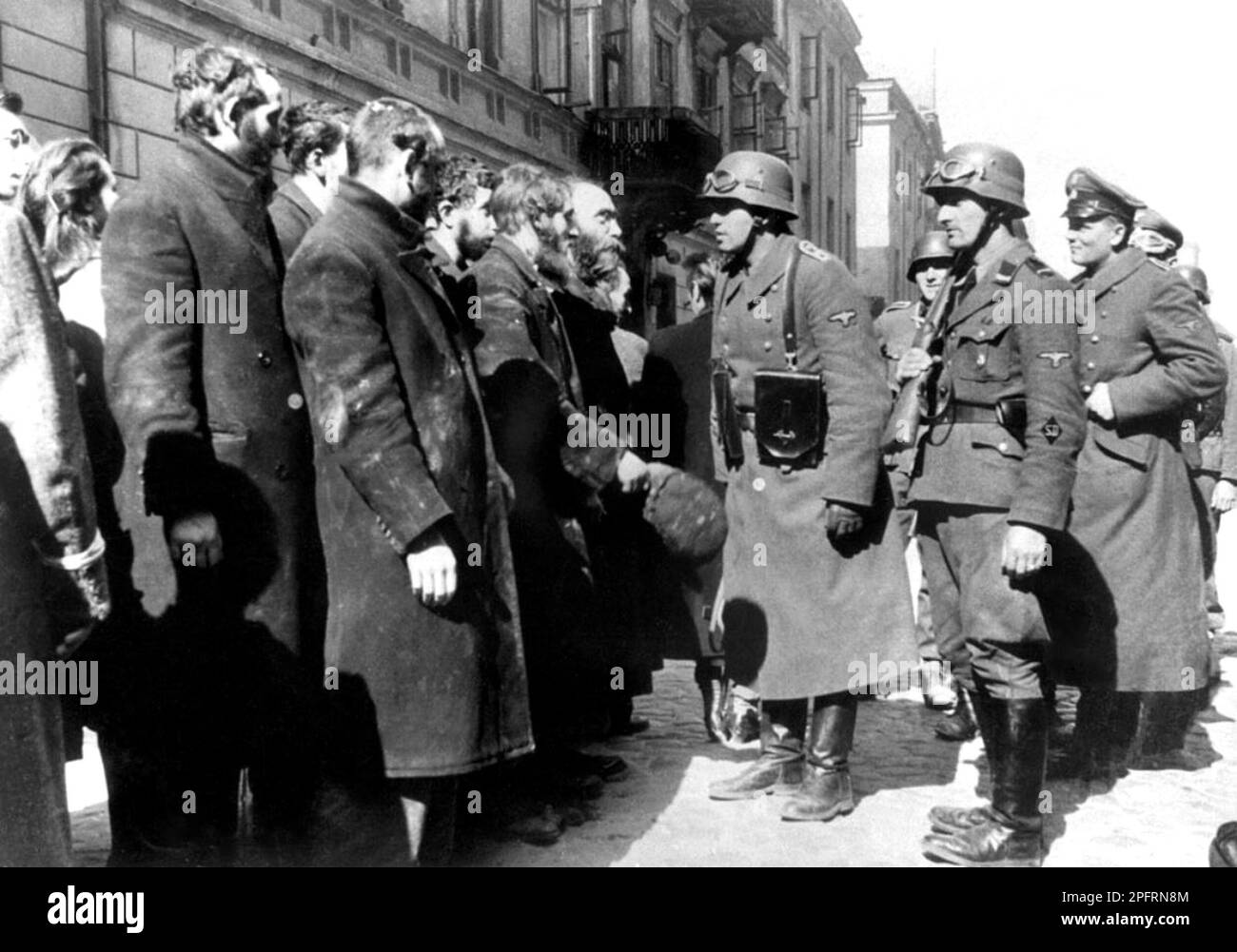 In January 1943 the nazis arrived to round up the Jews of the Warsaw Ghetto  The Jews, resolved to fight it out, took on the SS with homemade and primitive weapons. The defenders were executed or deported and the Ghetto area was systematically demolished. This event is known as The Ghetto Uprising.This image shows German soldiers talking to Rabbi Heschel Rappaport. This image is from the German photographic record of the event, known as the Stroop report. Stock Photo