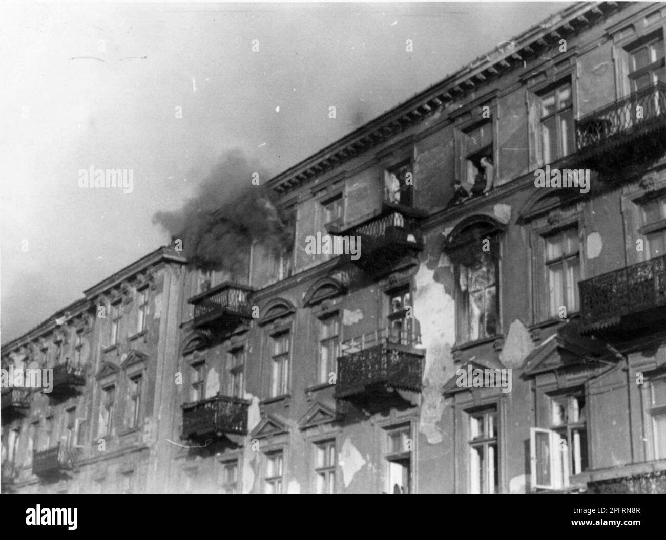 In January 1943 the nazis arrived to round up the Jews of the Warsaw Ghetto  The Jews, resolved to fight it out, took on the SS with homemade and primitive weapons. The defenders were executed or deported and the Ghetto area was systematically demolished. This event is known as The Ghetto Uprising. This image shows a group of Jews in an upstairs window preparing to jump rather than be caught. This image is from the German photographic record of the event, known as the Stroop report. Stock Photo