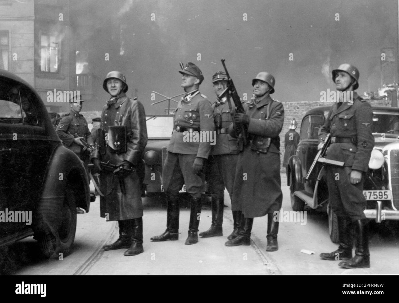 In January 1943 the nazis arrived to round up the Jews of the Warsaw Ghetto  The Jews, resolved to fight it out, took on the SS with homemade and primitive weapons. The defenders were executed or deported and the Ghetto area was systematically demolished. This event is known as The Ghetto Uprising. This image shows SS leader Jurgen Stroop (centre, peaked cap) observing and guiding the action.  This image is from the German photographic record of the event, known as the Stroop report. Stroop was hanged in 1952 for these events. Stock Photo