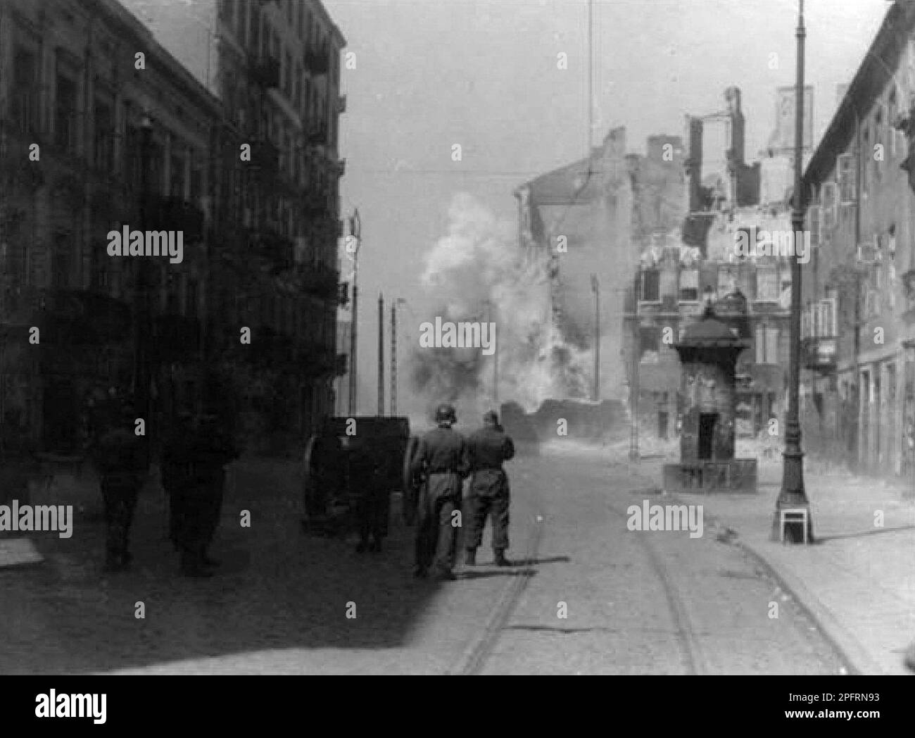 In January 1943 the nazis arrived to round up the Jews of the Warsaw Ghetto  The Jews, resolved to fight it out, took on the SS with homemade and primitive weapons. The defenders were executed or deported and the Ghetto area was systematically demolished. This event is known as The Ghetto Uprising.This image shows a German unit shelling a housing block. in Zamenhof Street. This image is from the German photographic record of the event, known as the Stroop report. Stock Photo