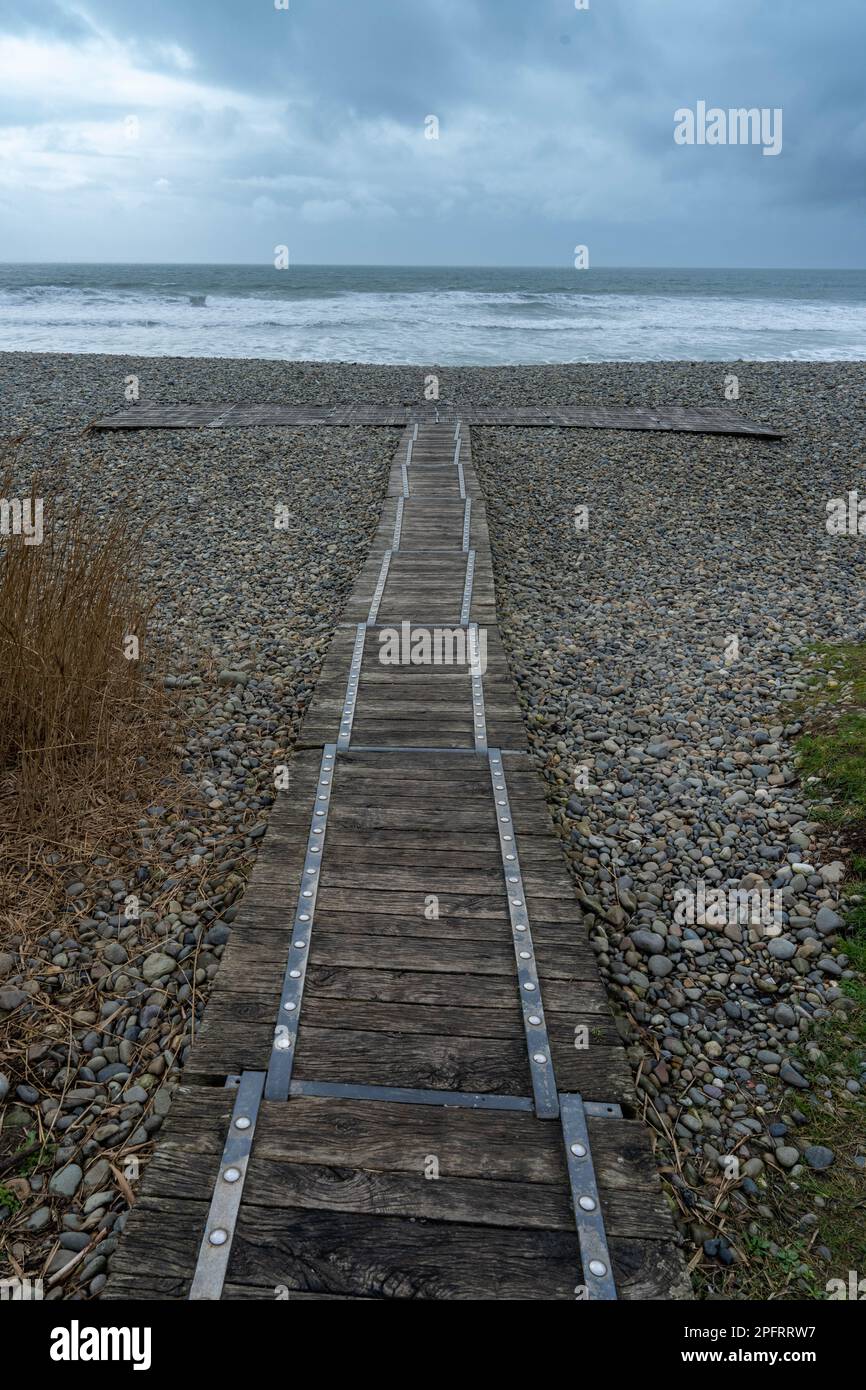 Wooden walkway on to the stoney beach Stock Photo