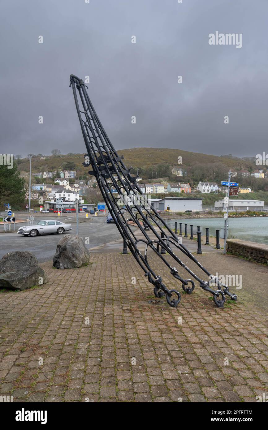 sculpture of a fishing net with fish made of metal alongside harbour wall at Fishgaurd Pembrokeshire Stock Photo