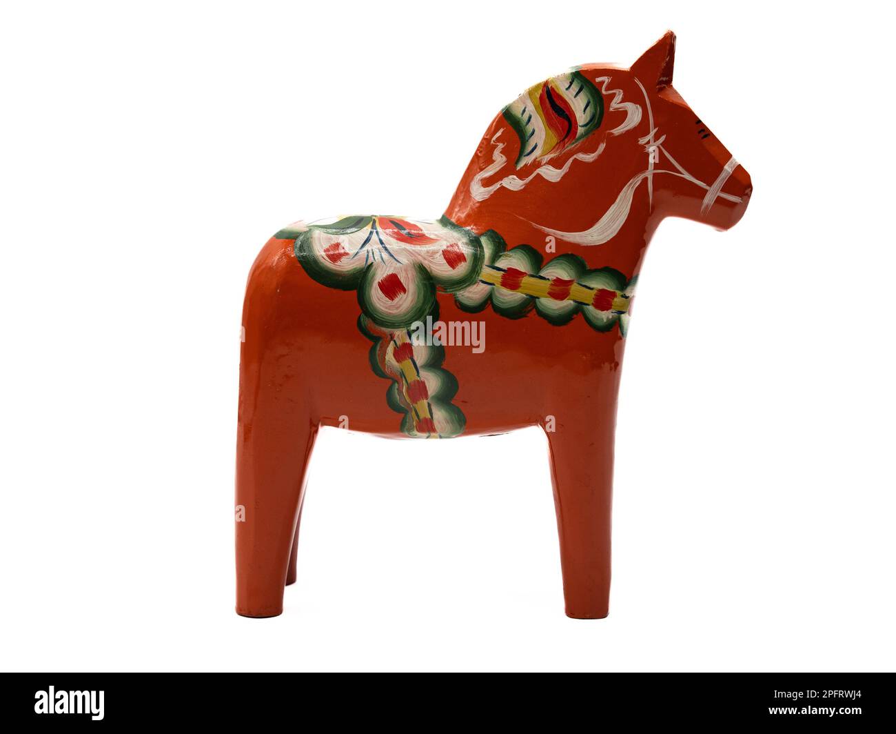 Traditional Swedish Dala Horse (Dalahäst) painted in many colors seen from the side against white background. Stock Photo
