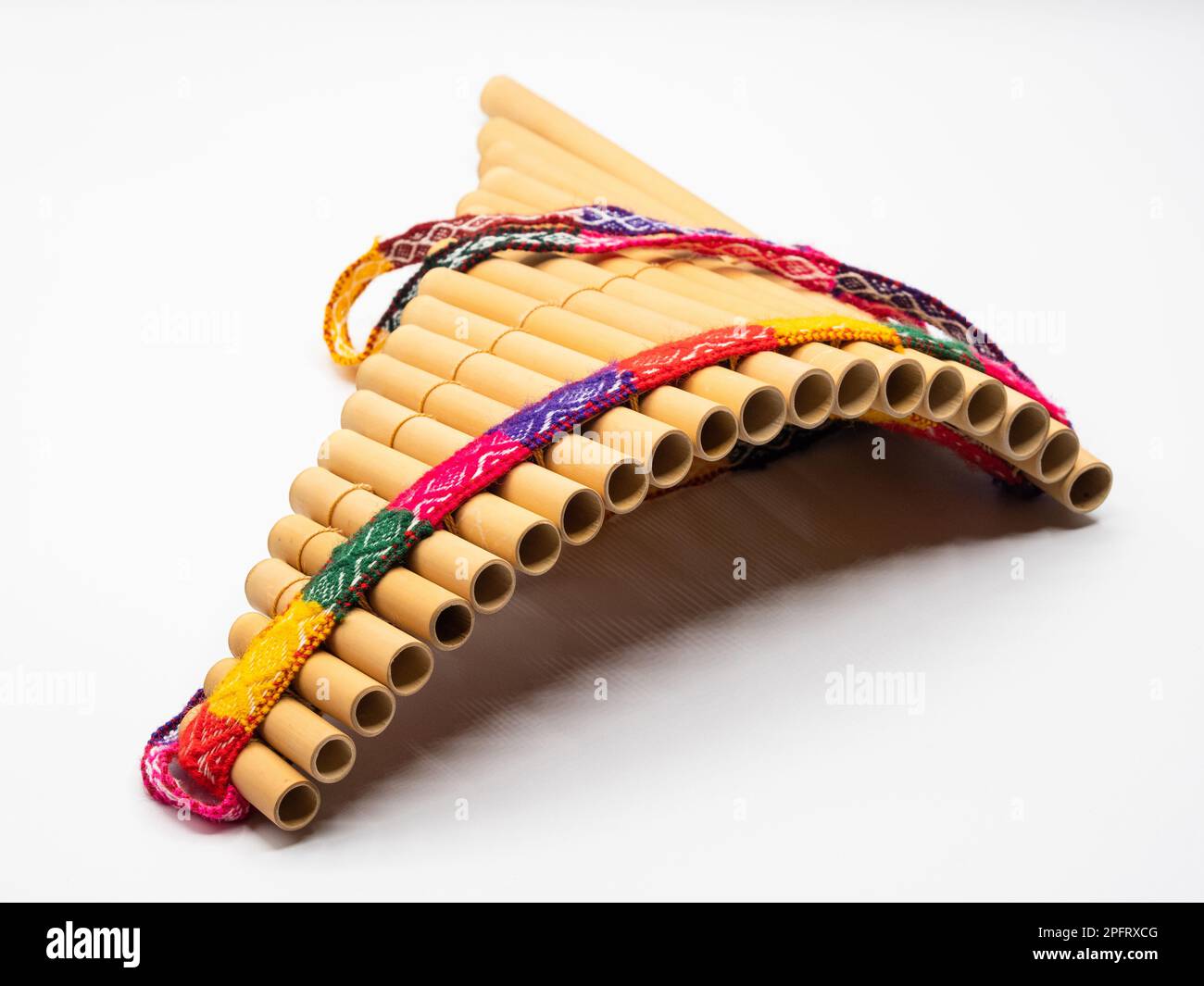 Pan flute with colorful band around against white background Stock
