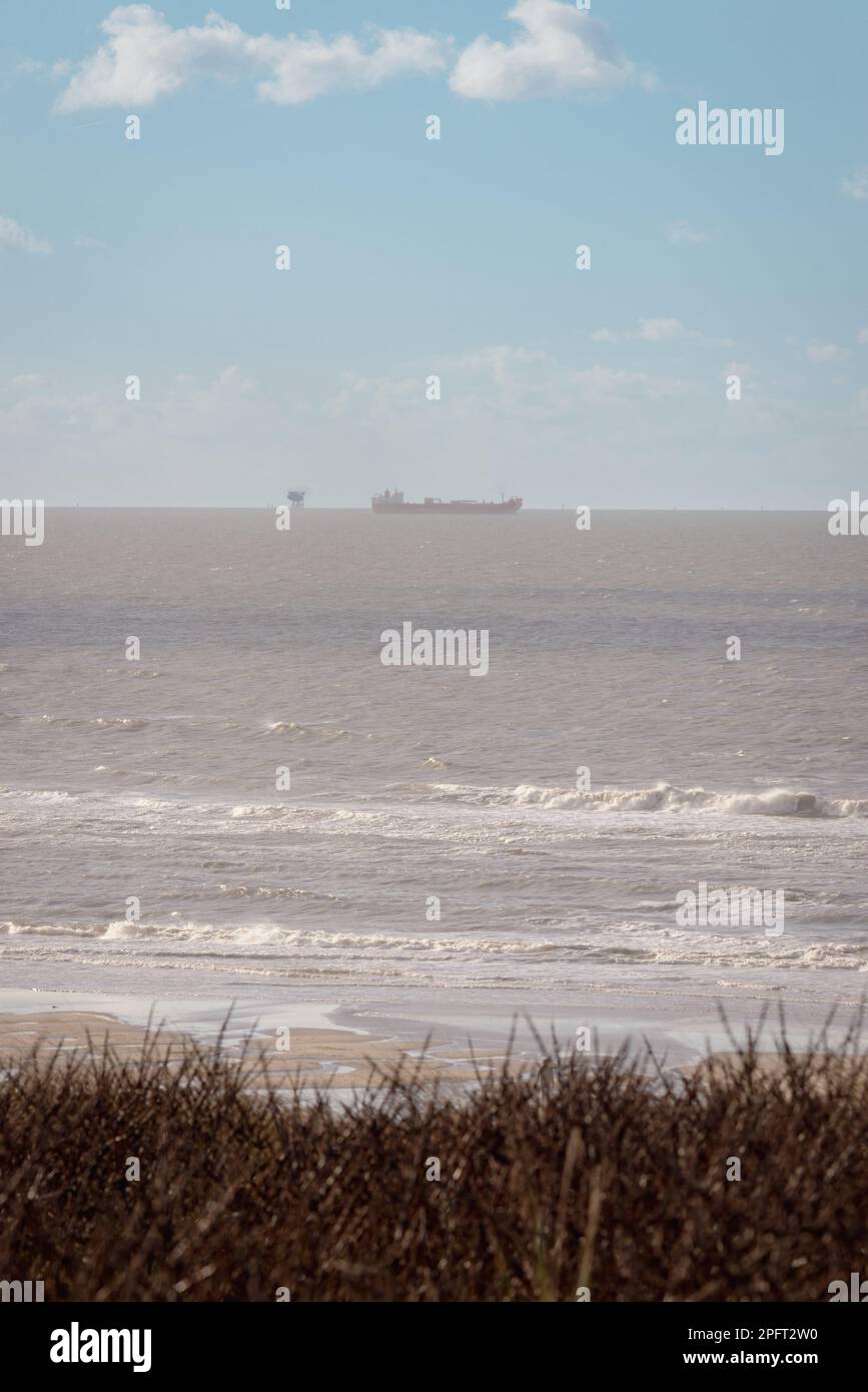Dunes on the Katwijk beach, Netherlands, with ships and wind turbines