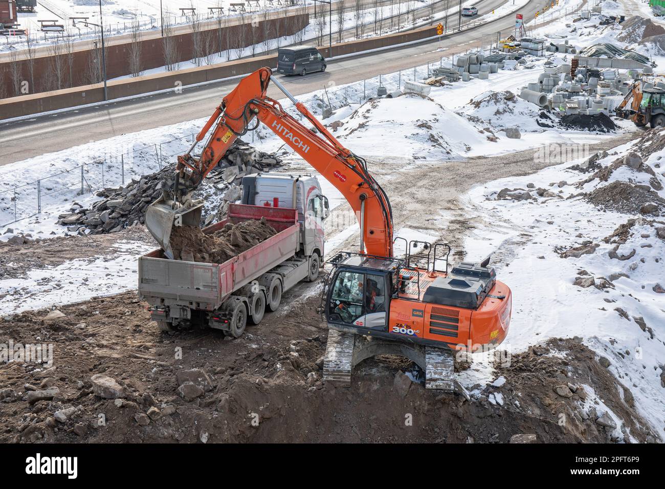 Hitachi ZX300LC tracked excavator loading a lorry in Pasila district of Helsinki, Finland Stock Photo