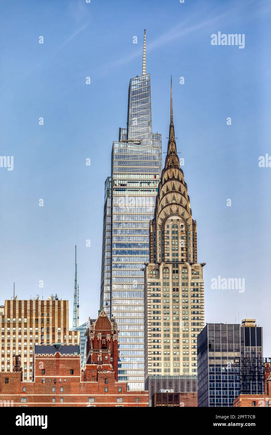 One Vanderbilt towers over New York City icon Chrysler Building against a bright sky with just a wisp of cloud. Stock Photo