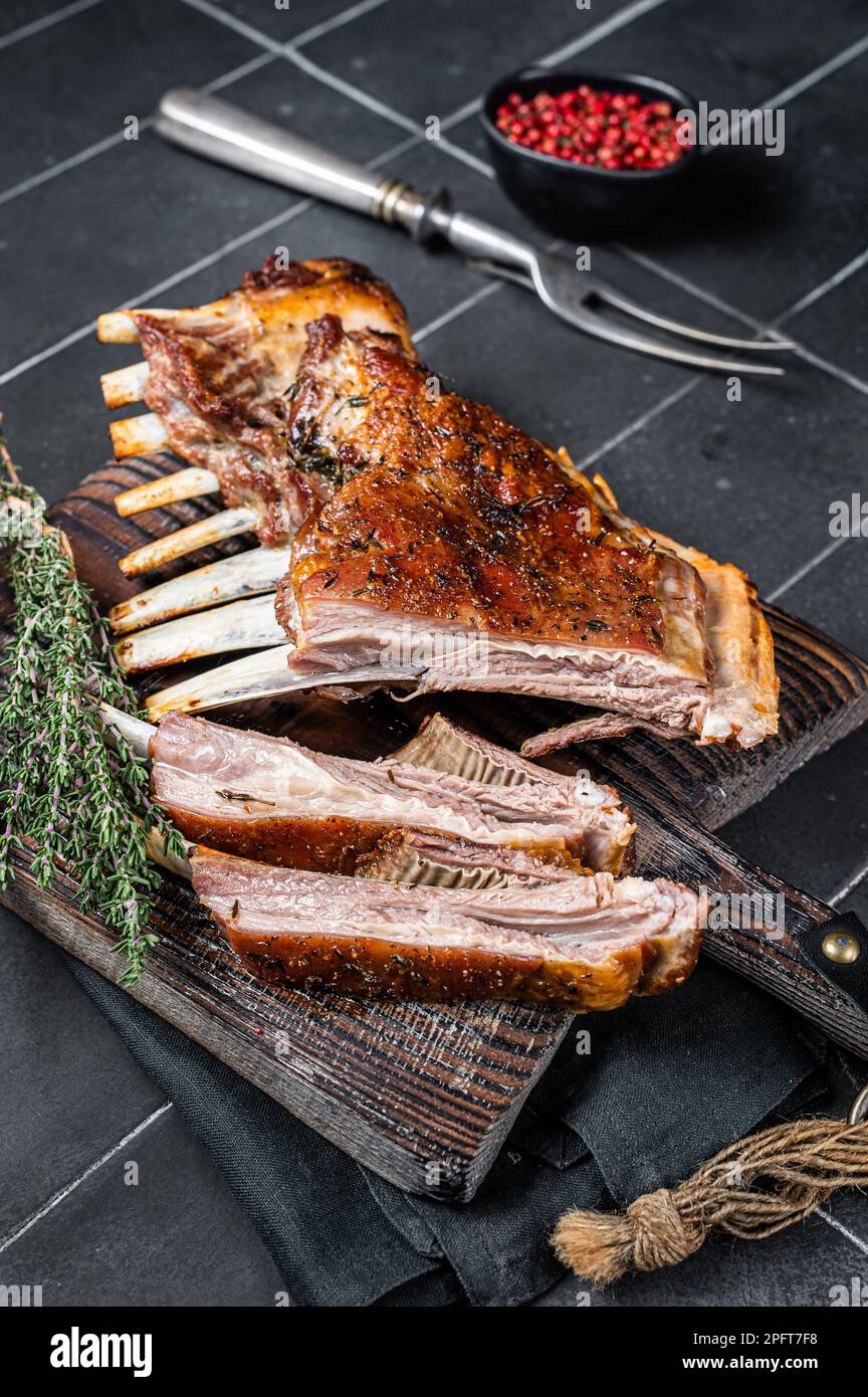Grilled Rack of lamb ribs, mutton spareribs on wooden board. Black ...