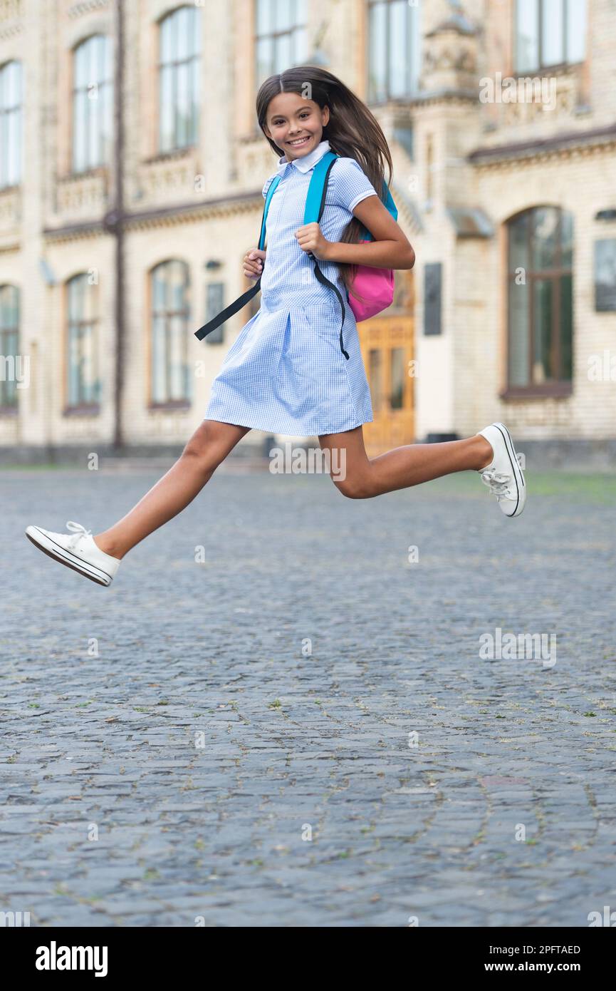 happy jumping school brunette girl. jumping school girl with backpack ...