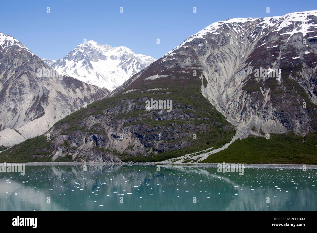 The springtime view of tall mountains and calm water with ice in Glacier Bay national park (Alaska). Stock Photo