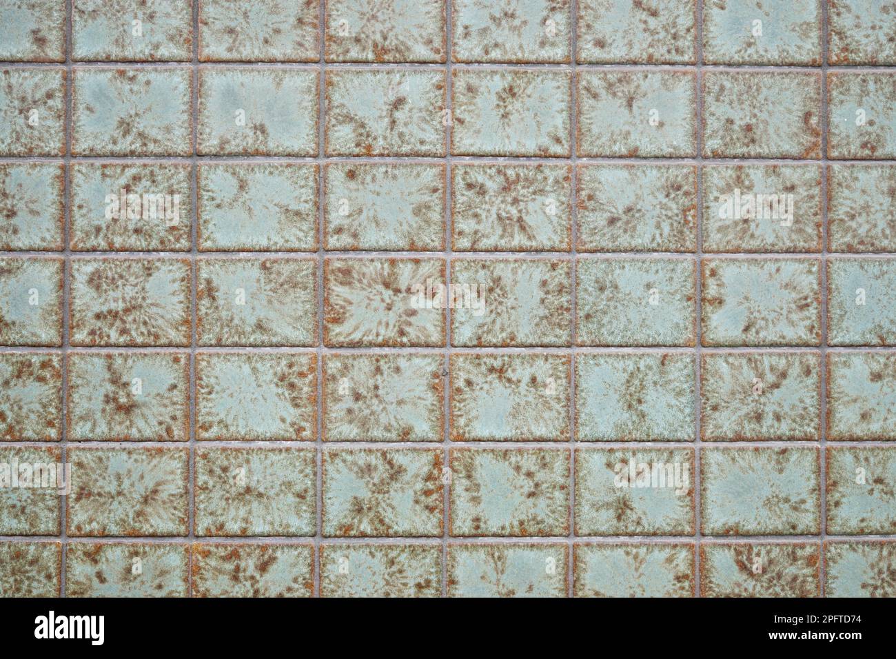 tiled exterior wall background with weathered green vintage tiling Stock Photo