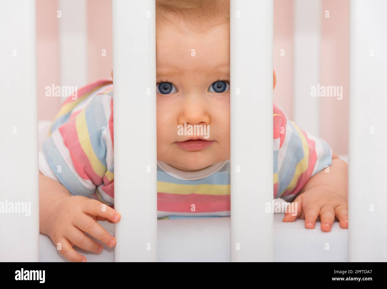 Toddler looks out of his cot Stock Photo Alamy