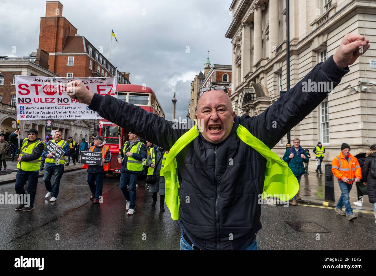 Protest against ULEZ zone expansion in London, UK. Angry Caucasian white male at head of protesters and Routemaster bus Stock Photo