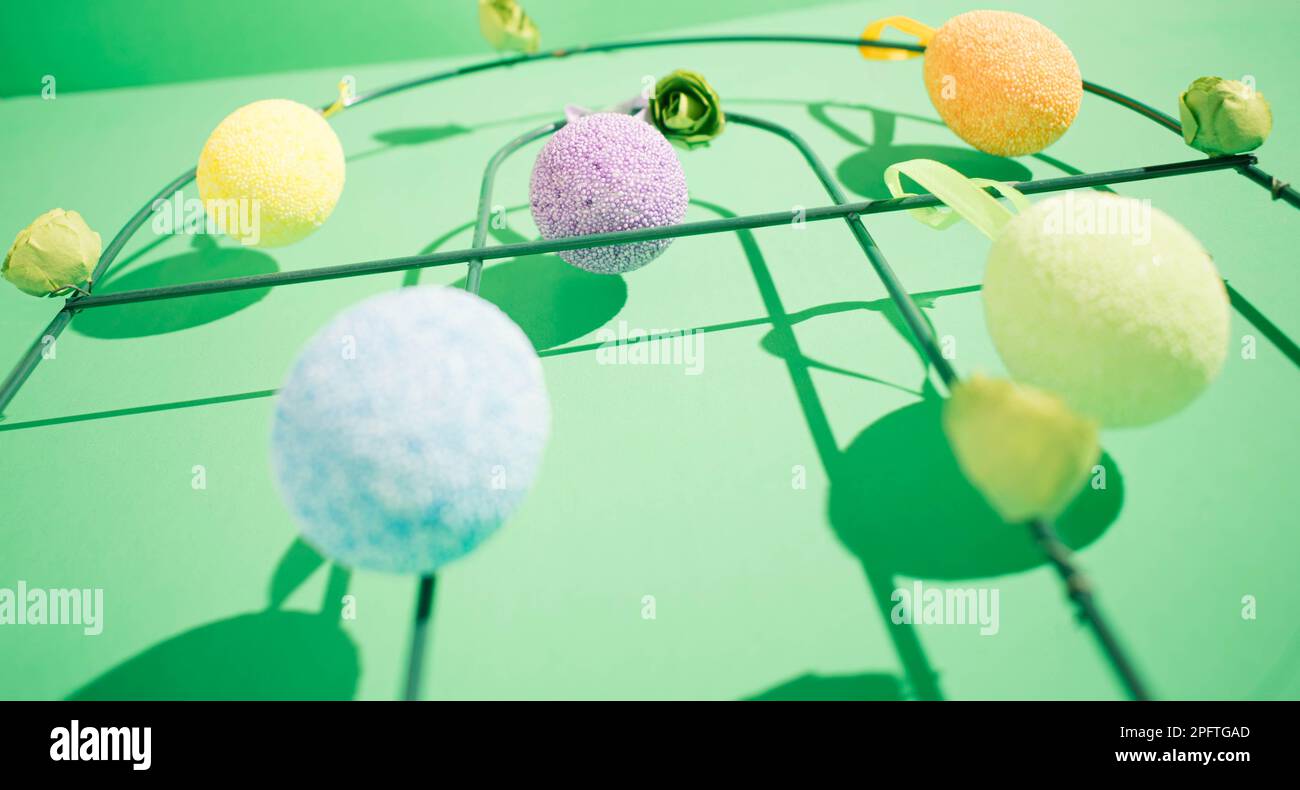 Hanging easter colorful eggs with a shadow on a green background Stock Photo