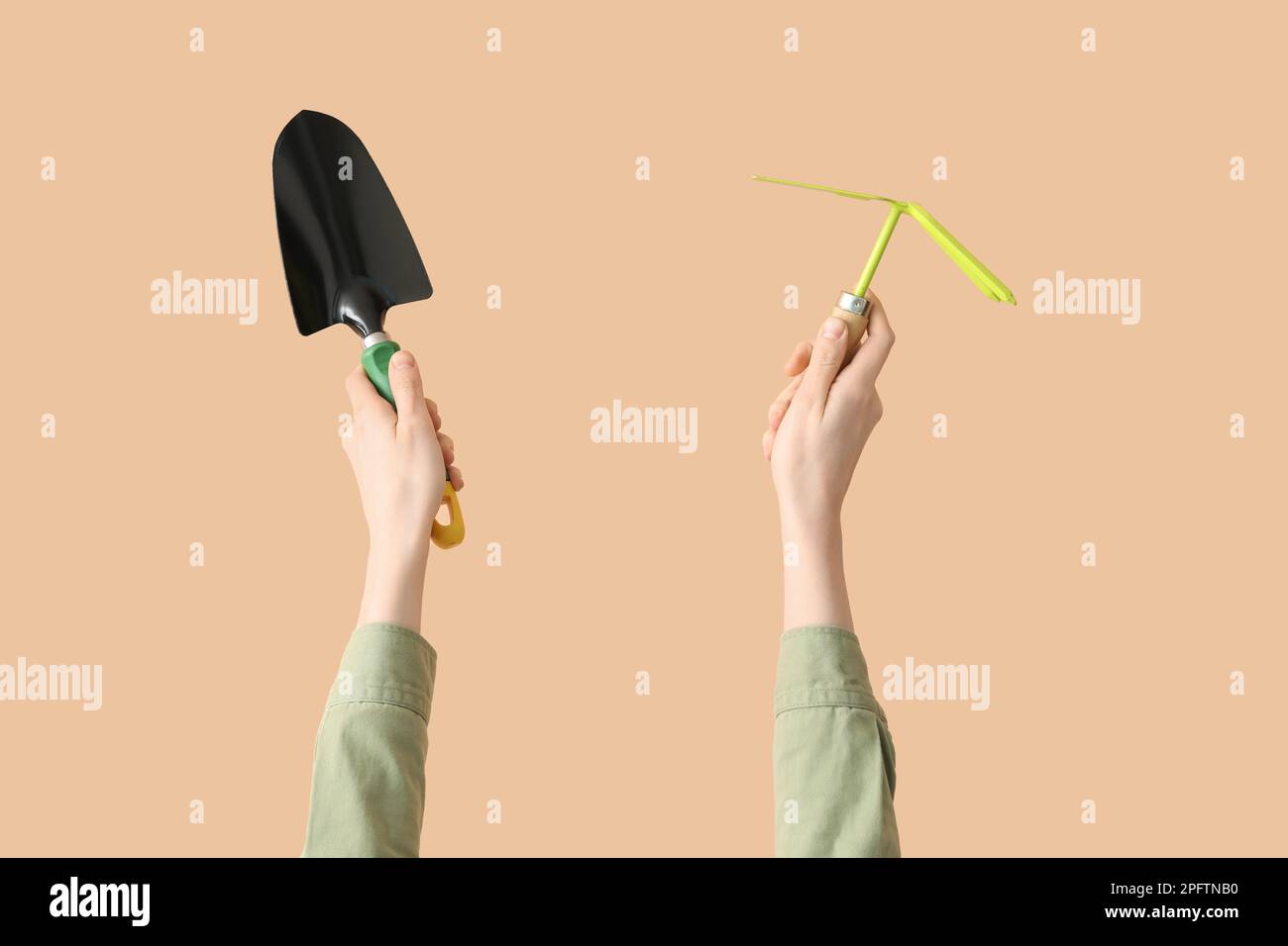 Female gardener with tools on beige background Stock Photo