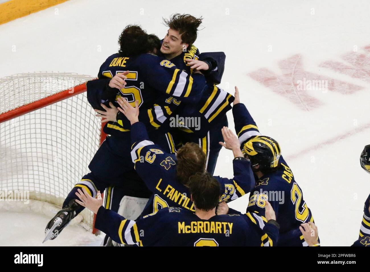 Michigan's Ethan Edwards, top right, Dylan Duke (25) and teammates