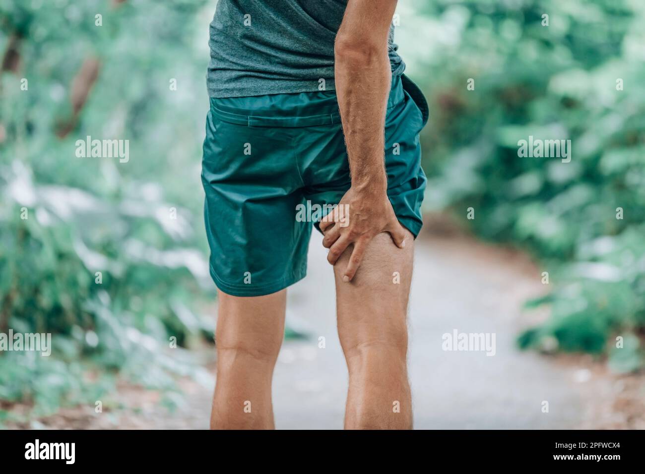 Leg muscle pain sports injury runner man touching painful hamstring