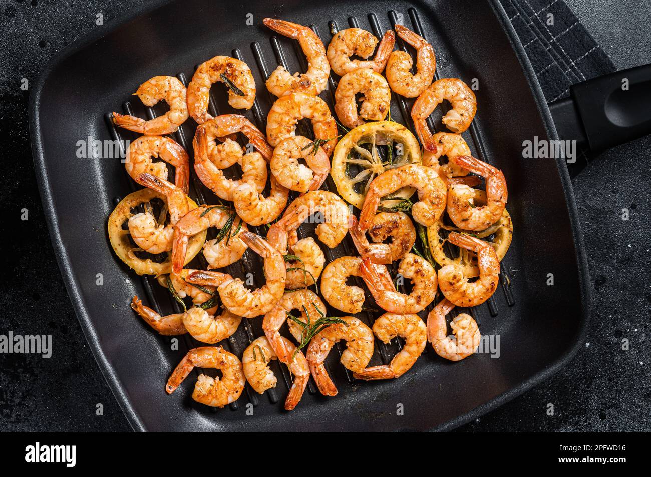 https://c8.alamy.com/comp/2PFWD16/roasted-prawns-shrimps-with-herbs-on-a-grill-skillet-black-background-top-view-2PFWD16.jpg