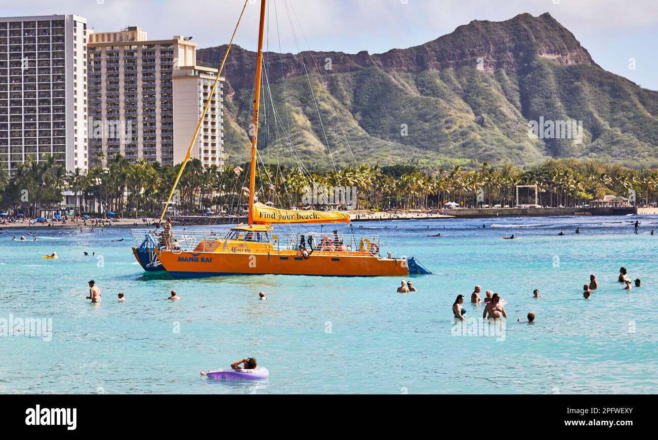 Waikiki, Oahu, Hawaii, USA, February 6, 2023 People swimming and surfing in Waikiki Beach