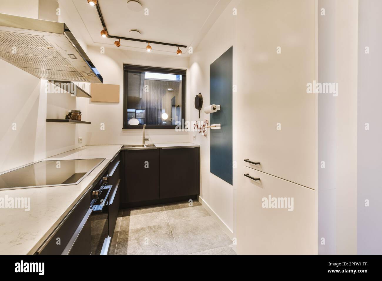 a modern kitchen with black cabinets and white marble countertops on ...