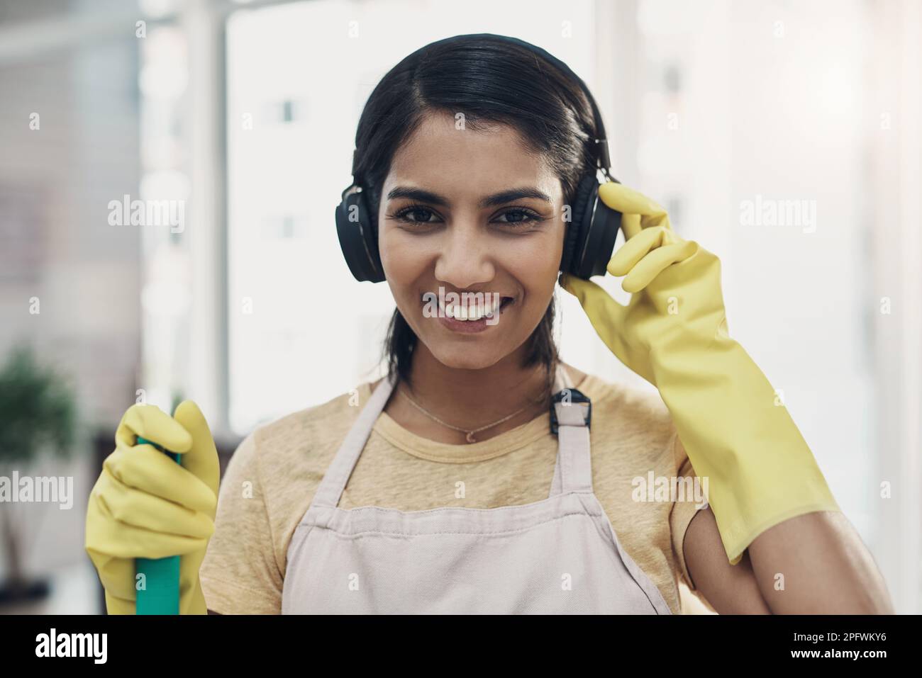 Getting into the domestic goddess groove. a young woman listening to