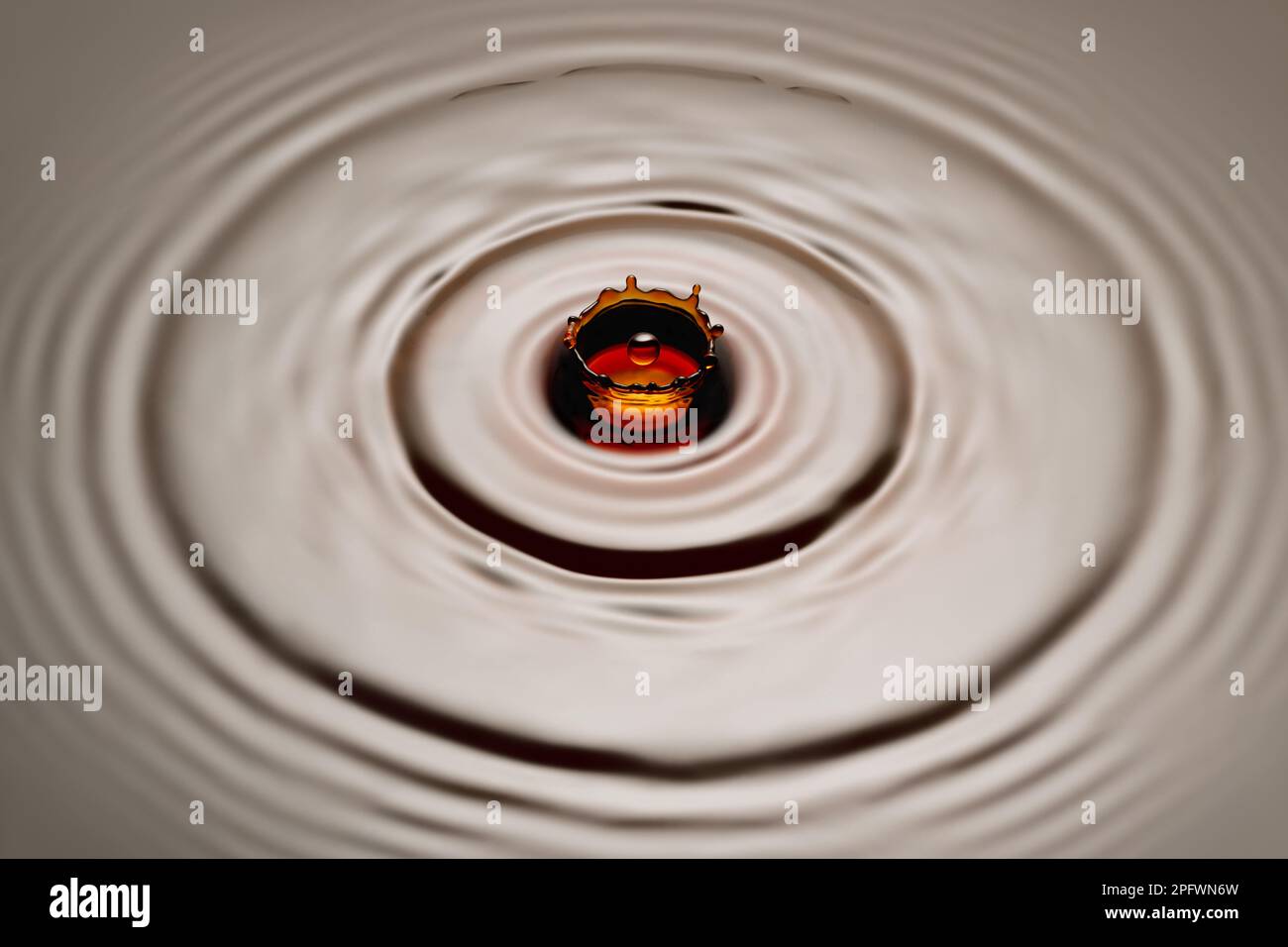 drop falling on soy sauce or brown liquid and created crown splash Stock Photo