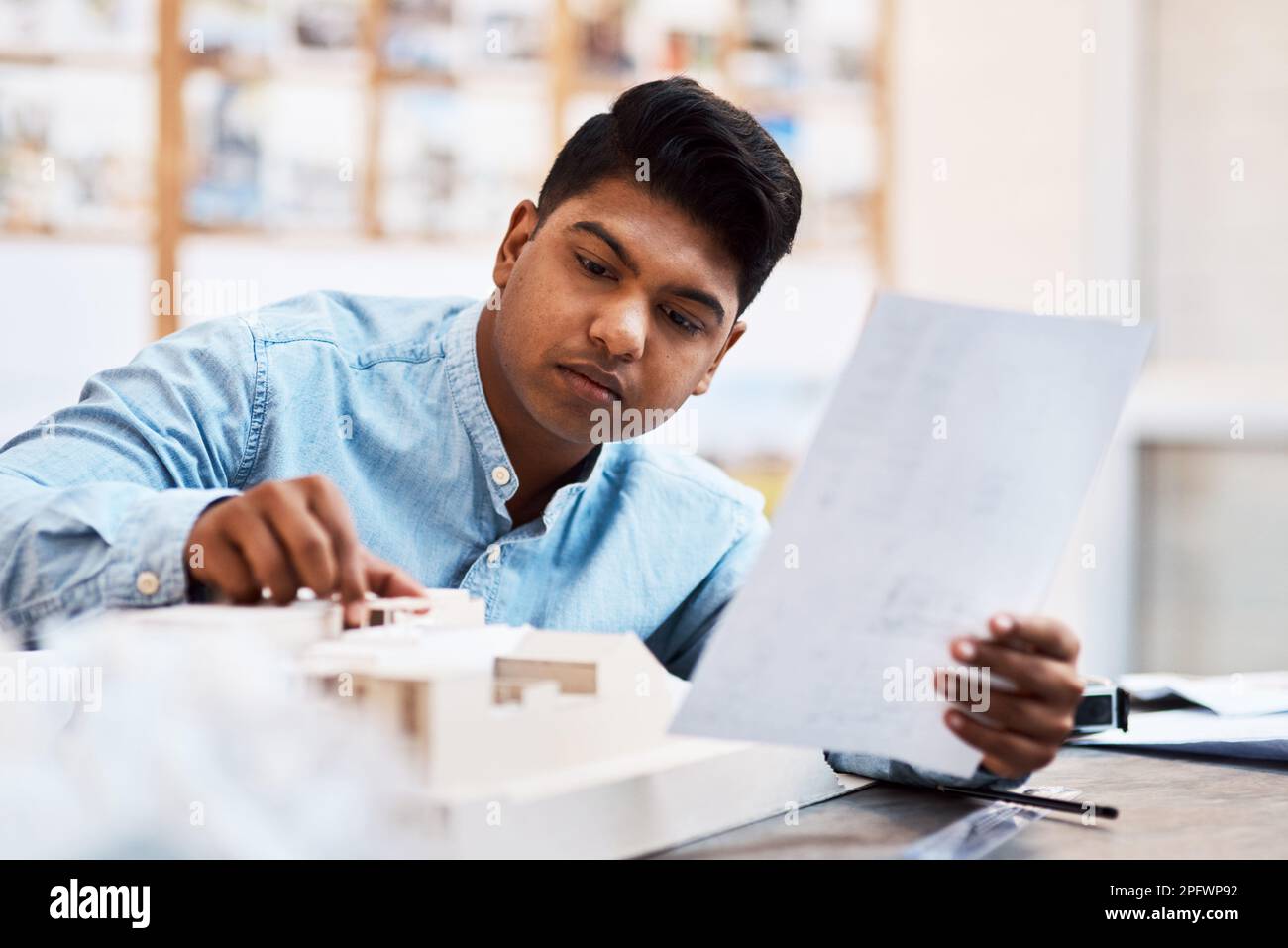 Nothing goes unnoticed. a young architect designing a building model in a modern office. Stock Photo