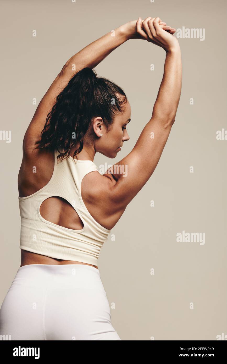 Rearview of a young female working out in a studio, engaging in muscle- toning stretch exercises. Athletic young woman striving for a lean and  muscular Stock Photo - Alamy