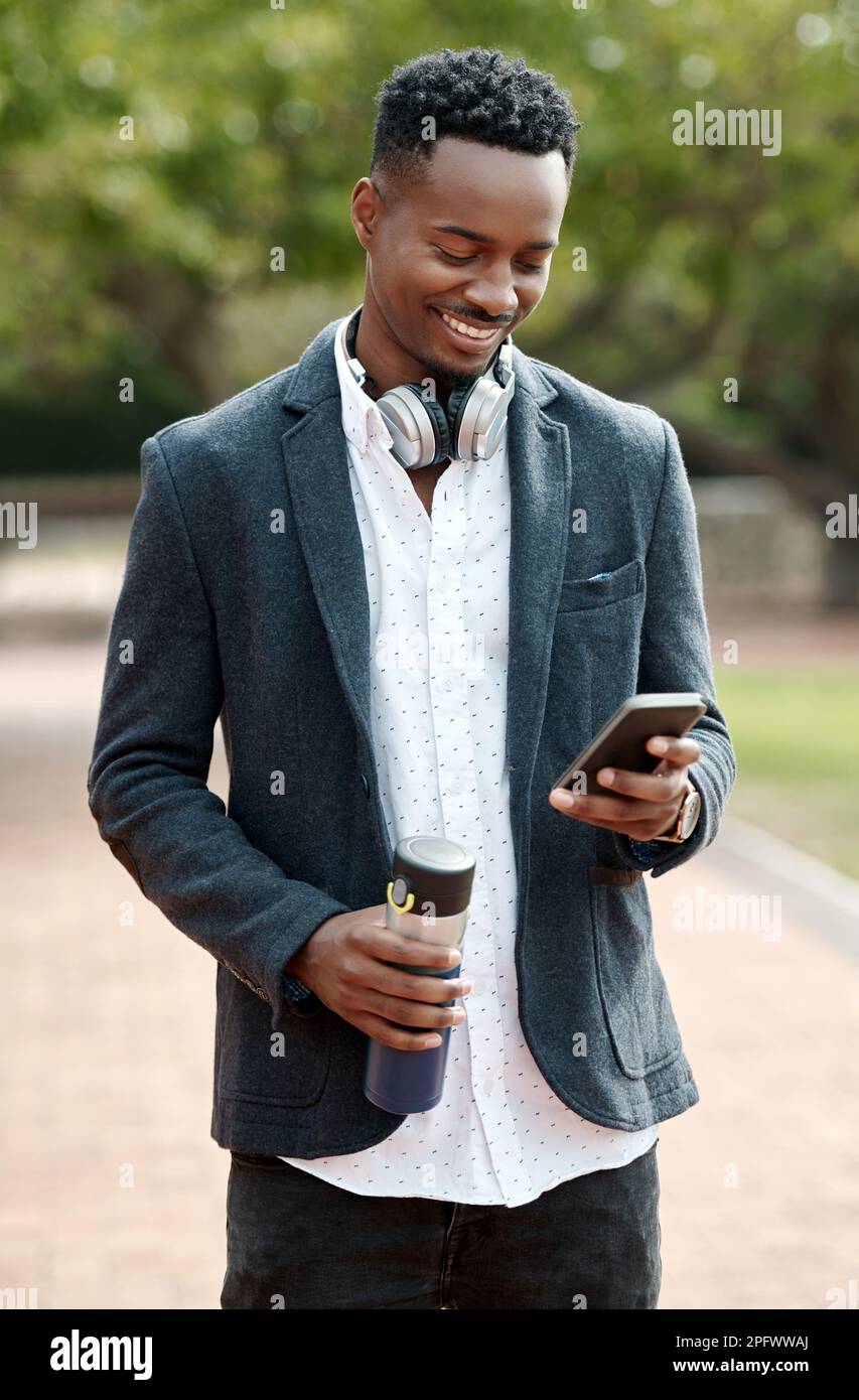 Every post keeps his followers captivated. a young businessman using a smartphone against an urban background. Stock Photo