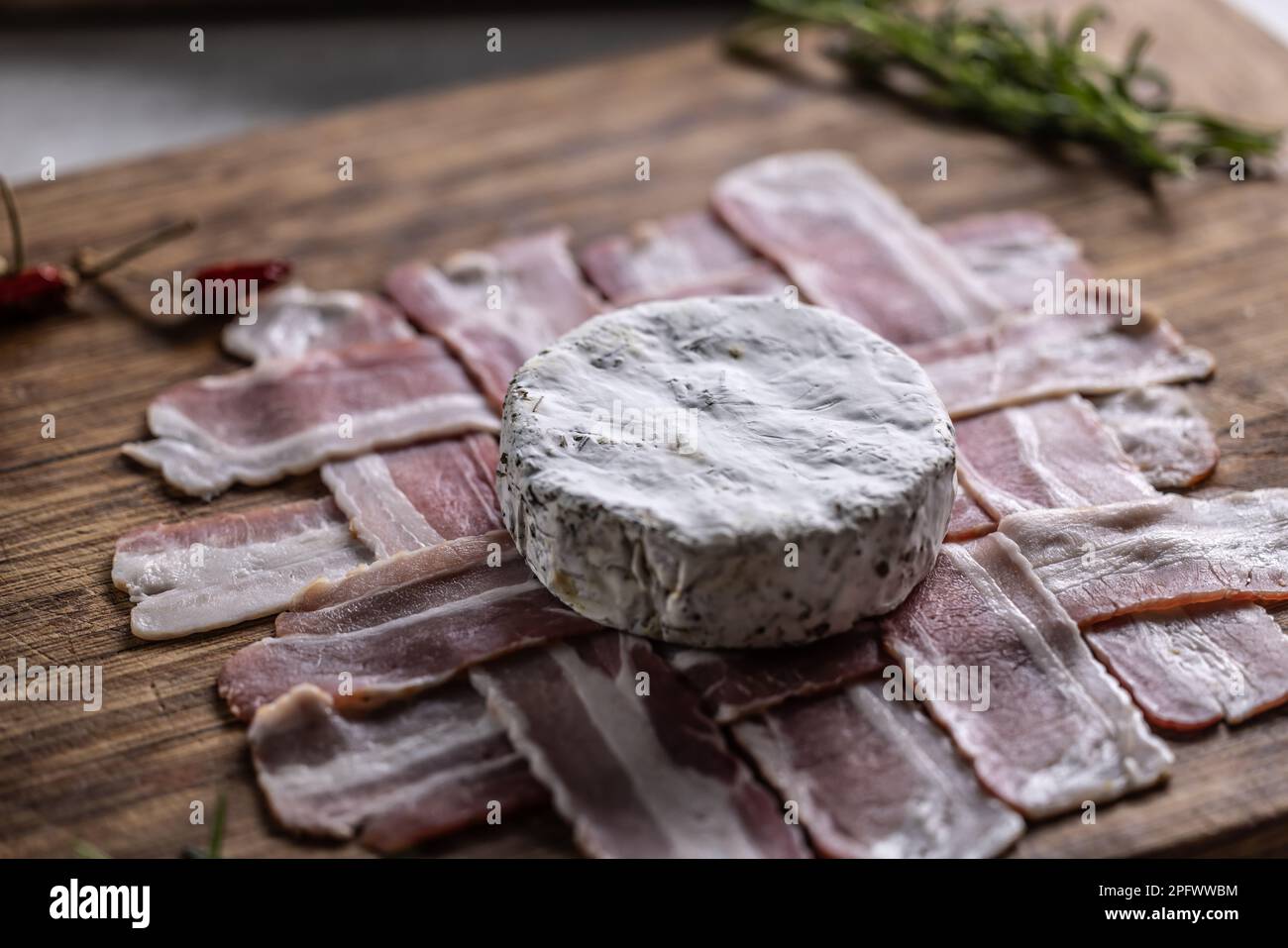Round camembert chees placed on a perfect griddle of bacon slices ...